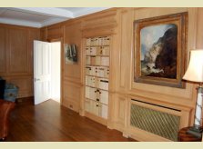 Hallidays polished pine room panelling showing radiator cover and false door lined with vellum-bound books